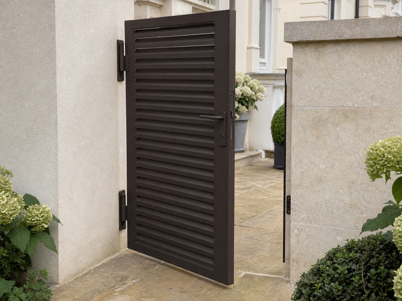 Bespoke dark-bronze louvred steel courtyard gate at a landscaped Belsize Park period property.